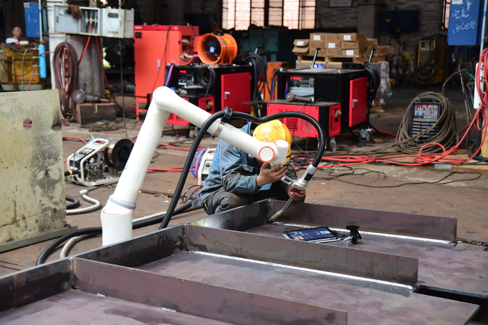 焊工师傅正在钻研调试自动焊接设备.jpg